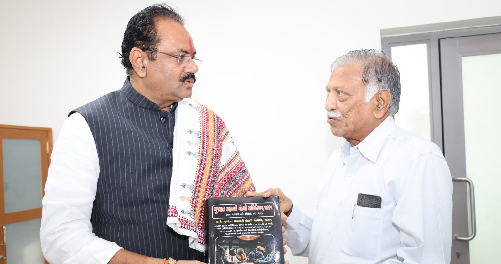 Amin presents book on Gujarat Co-op Law to Minister